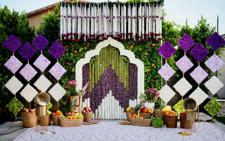 Outdoor wedding stage with purple and white floral lattice panels and a white arch by RAW Group